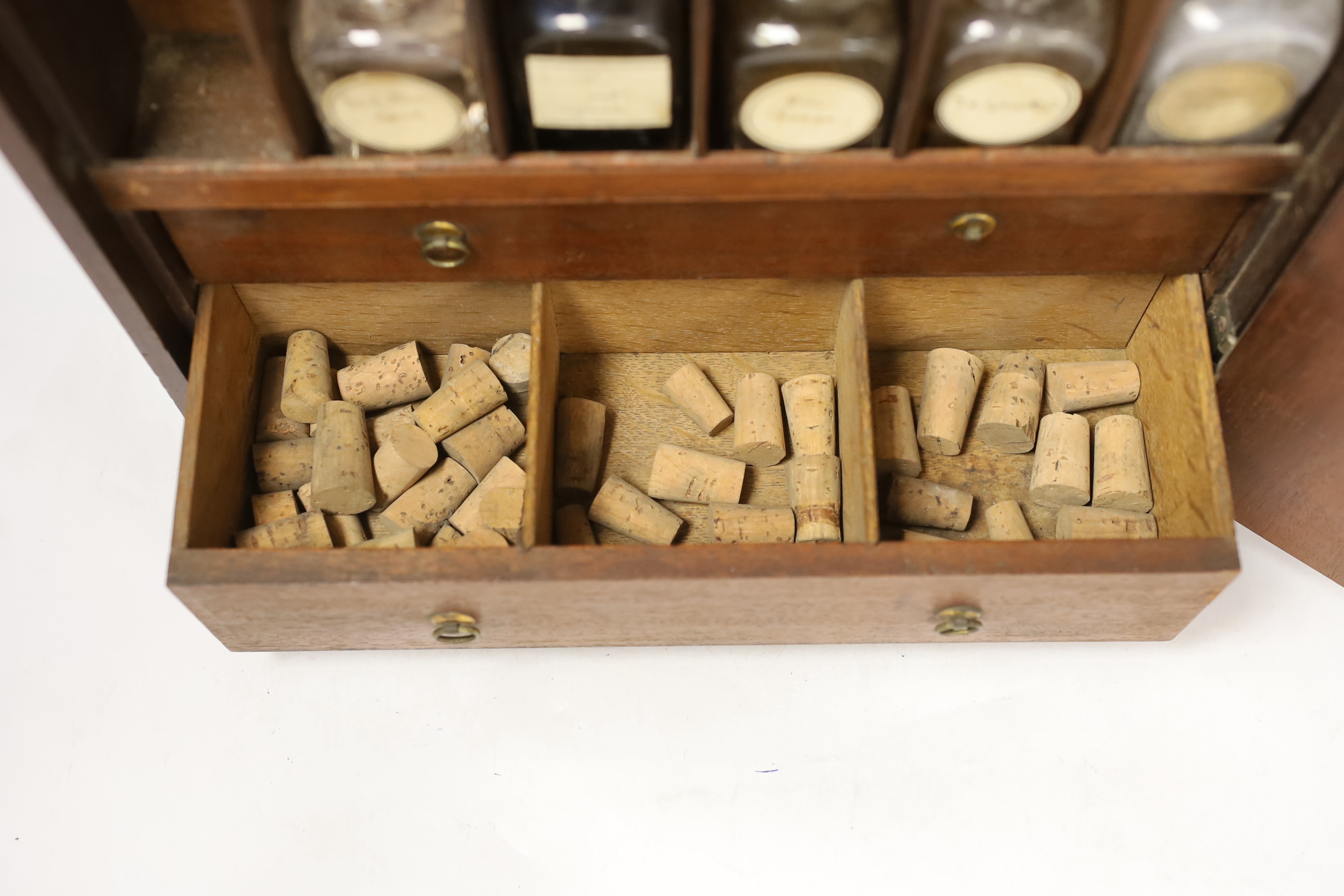 An early 19th century mahogany apothecary box, opening on both opposite sides and top lid, with fitted compartments and two drawers containing square section labelled glass bottles, oak and zinc lidded drawer sections, c